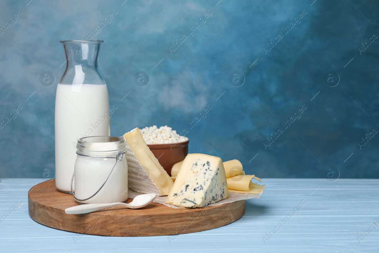 Photo of Fresh dairy products on table against color background