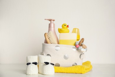 Photo of Baby booties and accessories on table against white background