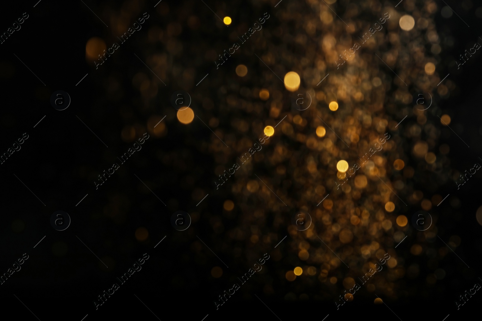 Photo of Blurred view of golden lights on black background. Bokeh effect