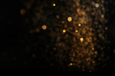 Photo of Blurred view of golden lights on black background. Bokeh effect