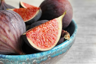 Photo of Bowl with fresh ripe figs on table, closeup. Tropical fruit