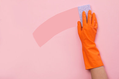 Image of Woman holding sponge on color background. Cleaning service