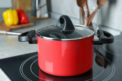 Pot with lid on cooktop in kitchen. Cooking utensil