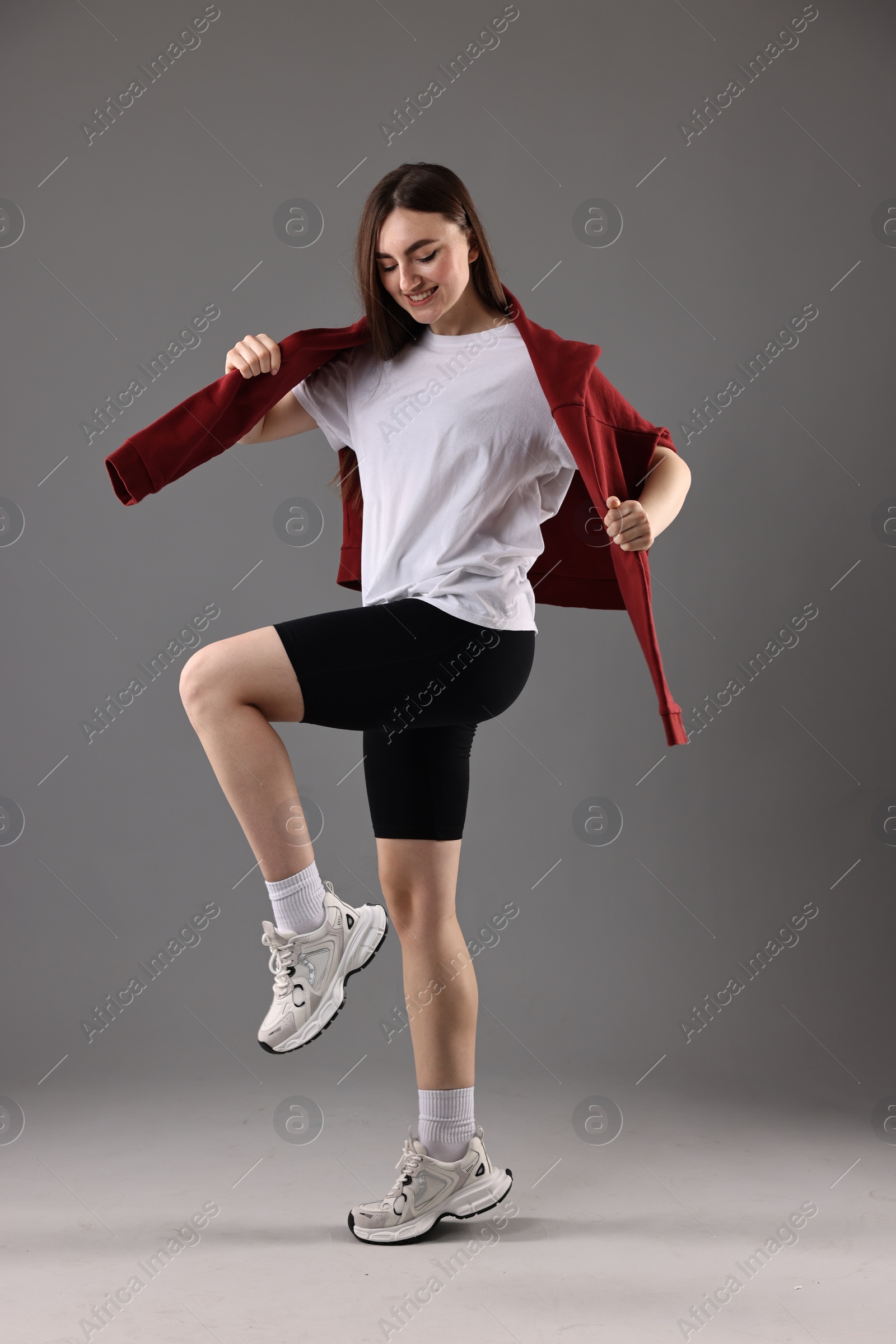 Photo of Happy woman in sportswear posing on grey background