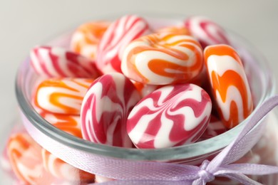 Photo of Delicious sweet candies in glass jar on light background, closeup