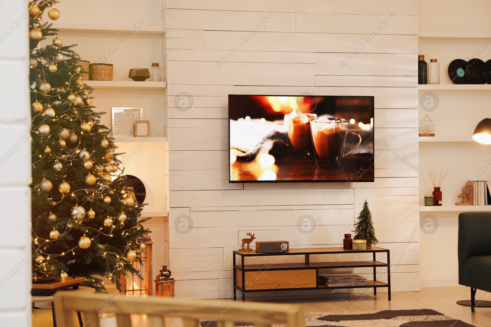 Photo of Plasma TV on white wooden wall in living room beautifully decorated for Christmas