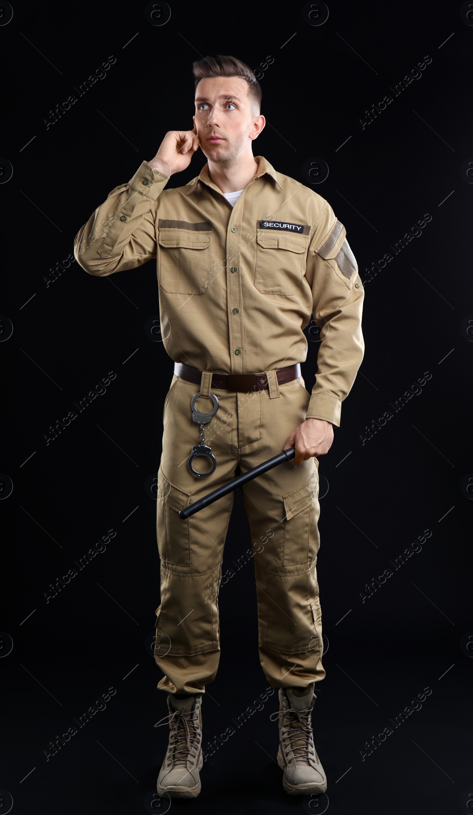 Photo of Male security guard using portable radio transmitter on dark background