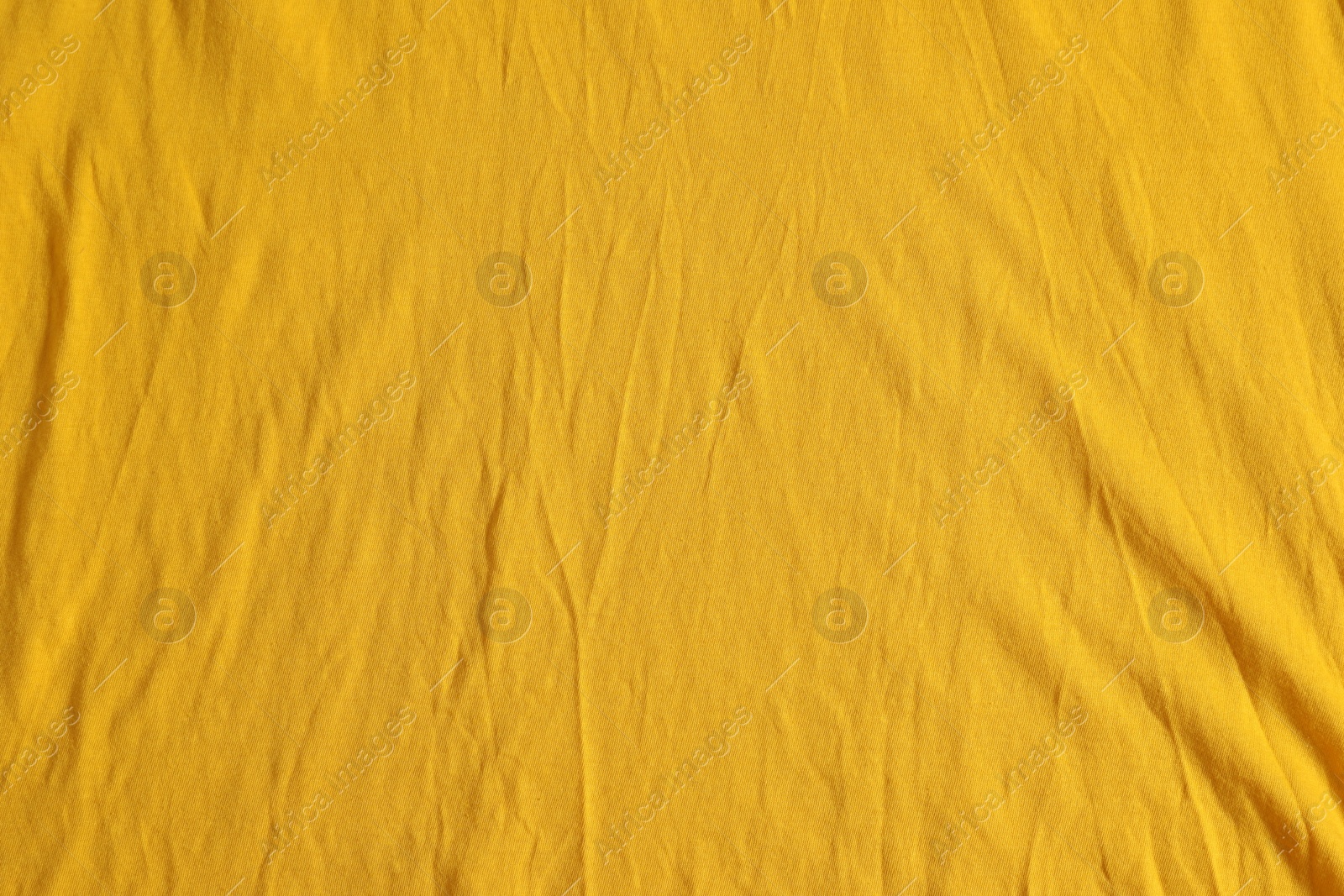 Photo of Crumpled orange fabric as background, top view