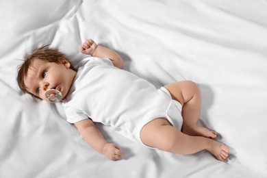 Photo of Cute little baby lying on bed, top view