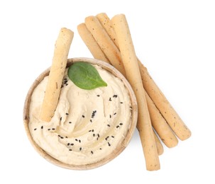 Delicious hummus with grissini sticks on white background, top view