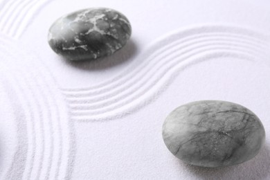 Photo of Stones on sand with pattern. Zen concept