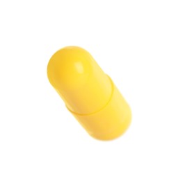 One yellow pill isolated on white. Medicinal treatment