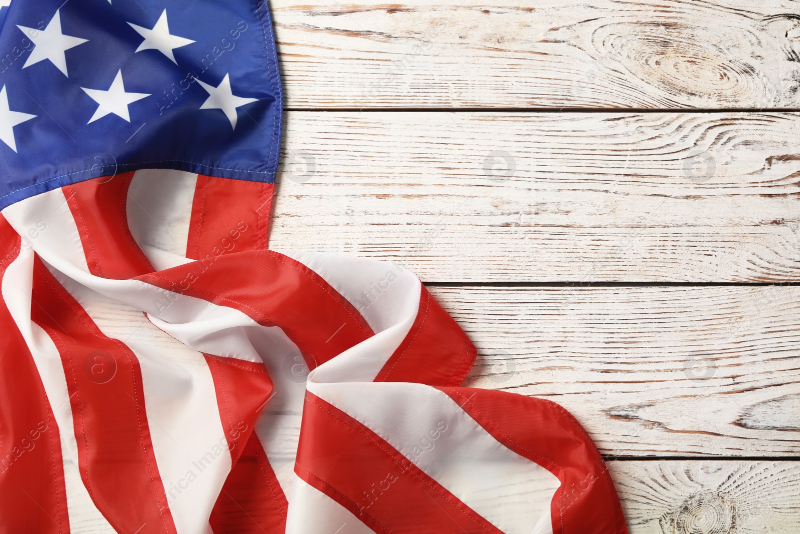 Photo of American flag on white wooden table, top view with space for text. Memorial Day