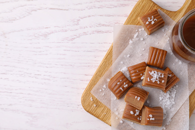 Delicious salted caramel on white wooden table, top view. Space for text