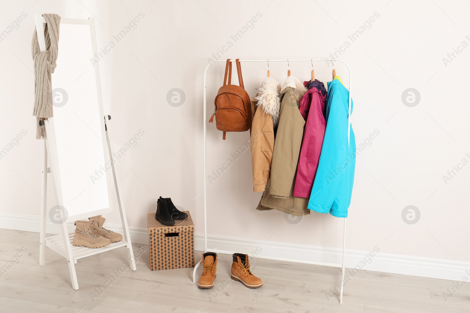 Photo of Modern hallway interior with mirror and clothes on hanger stand