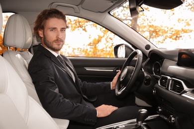 Photo of Young handsome man in driver's seat of modern car