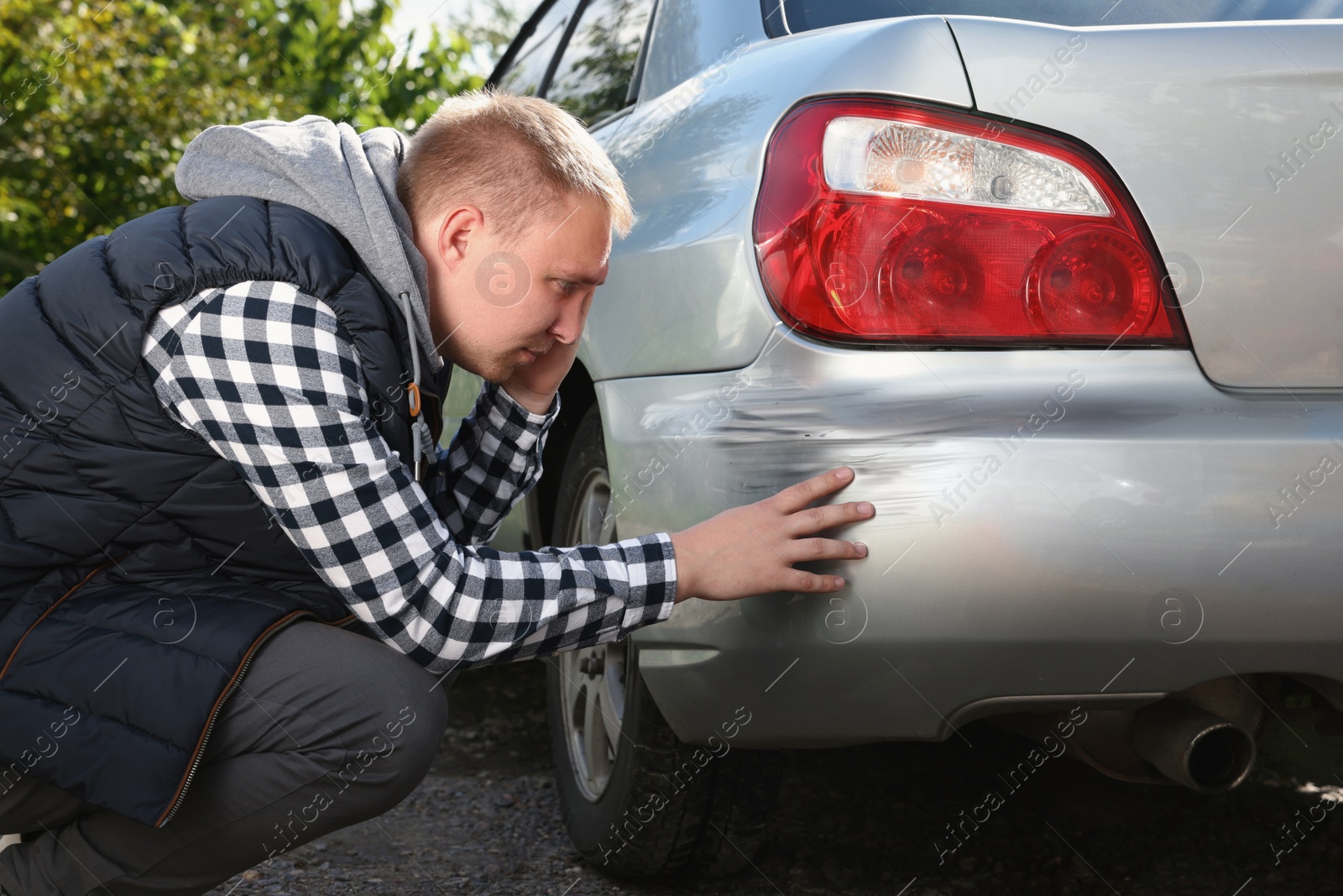 Photo of Stressed man near car with scratch outdoors