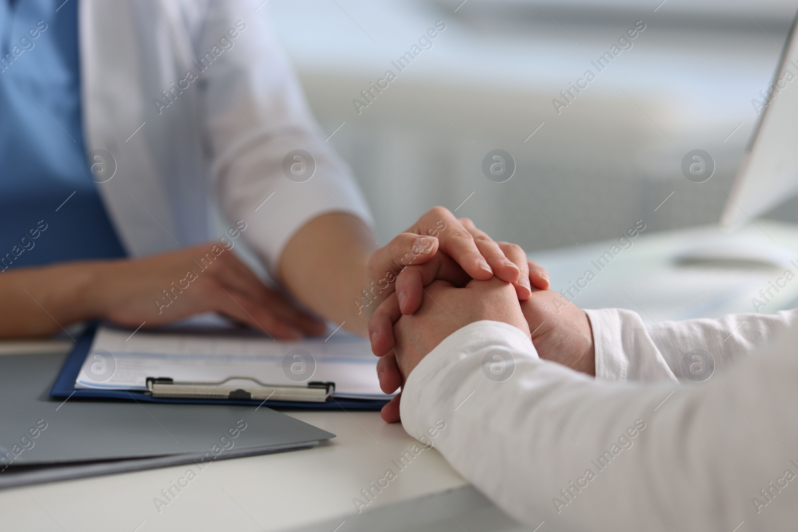 Photo of Professional doctor working with patient at white table in hospital, closeup