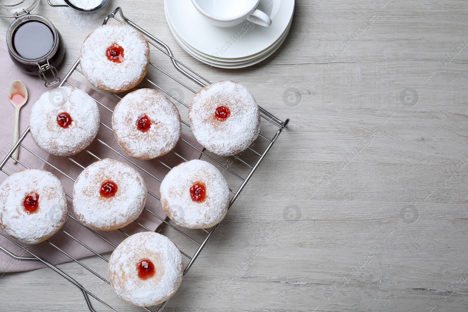 Photo of Many delicious donuts with jelly and powdered sugar on wooden table, flat lay. Space for text