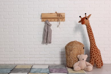 Beautiful children's room with white brick wall and toys, space for text. Interior design