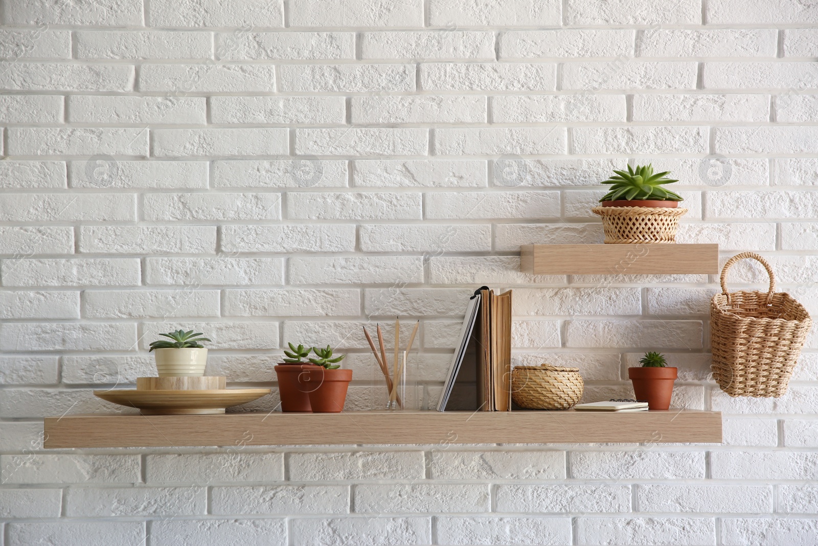 Photo of Shelves with decorative elements on white brick wall. Interior design