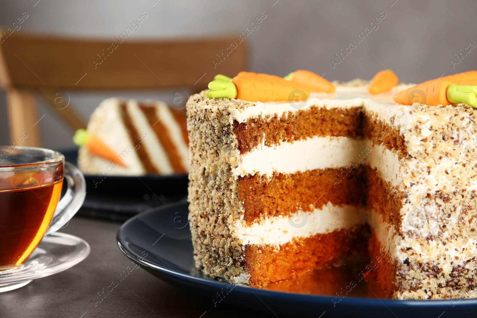 Photo of Tasty carrot cake and cup of fresh tea on grey table