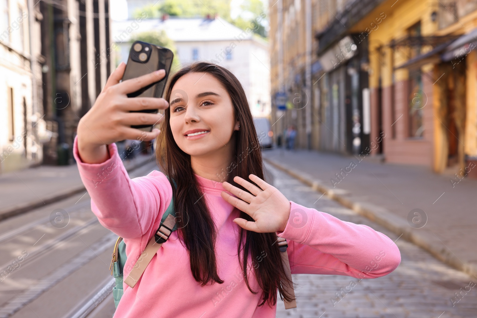 Photo of Travel blogger with smartphone streaming on city street