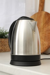 Photo of Modern electric kettle on counter in kitchen