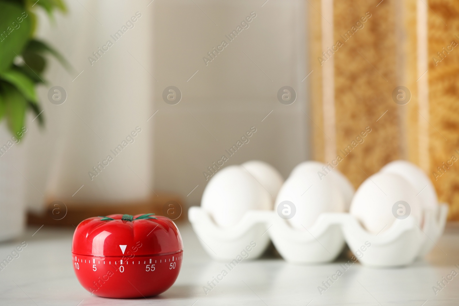 Photo of Kitchen timer in shape of tomato and eggs on white table. Space for text