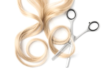 Photo of Curly blond hair and thinning scissors on white background, top view. Hairdresser service