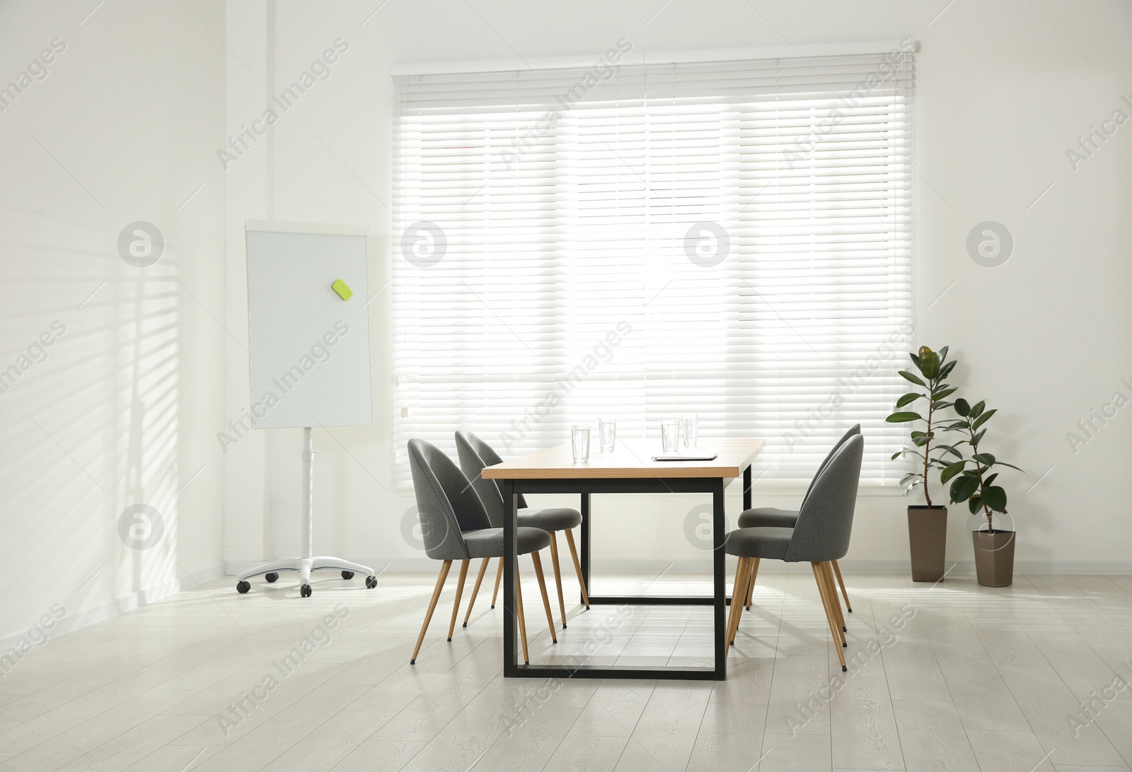 Photo of Conference room interior with wooden table and flipchart