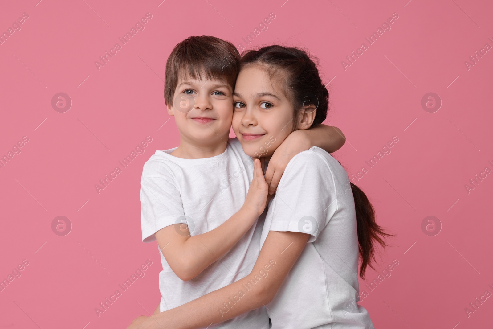 Photo of Happy brother and sister on pink background