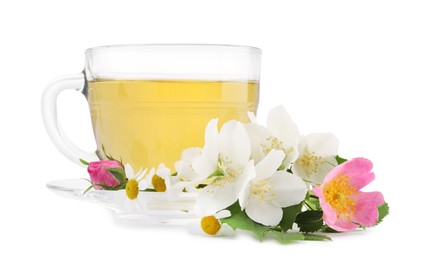 Photo of Aromatic herbal tea in glass cup and flowers isolated on white