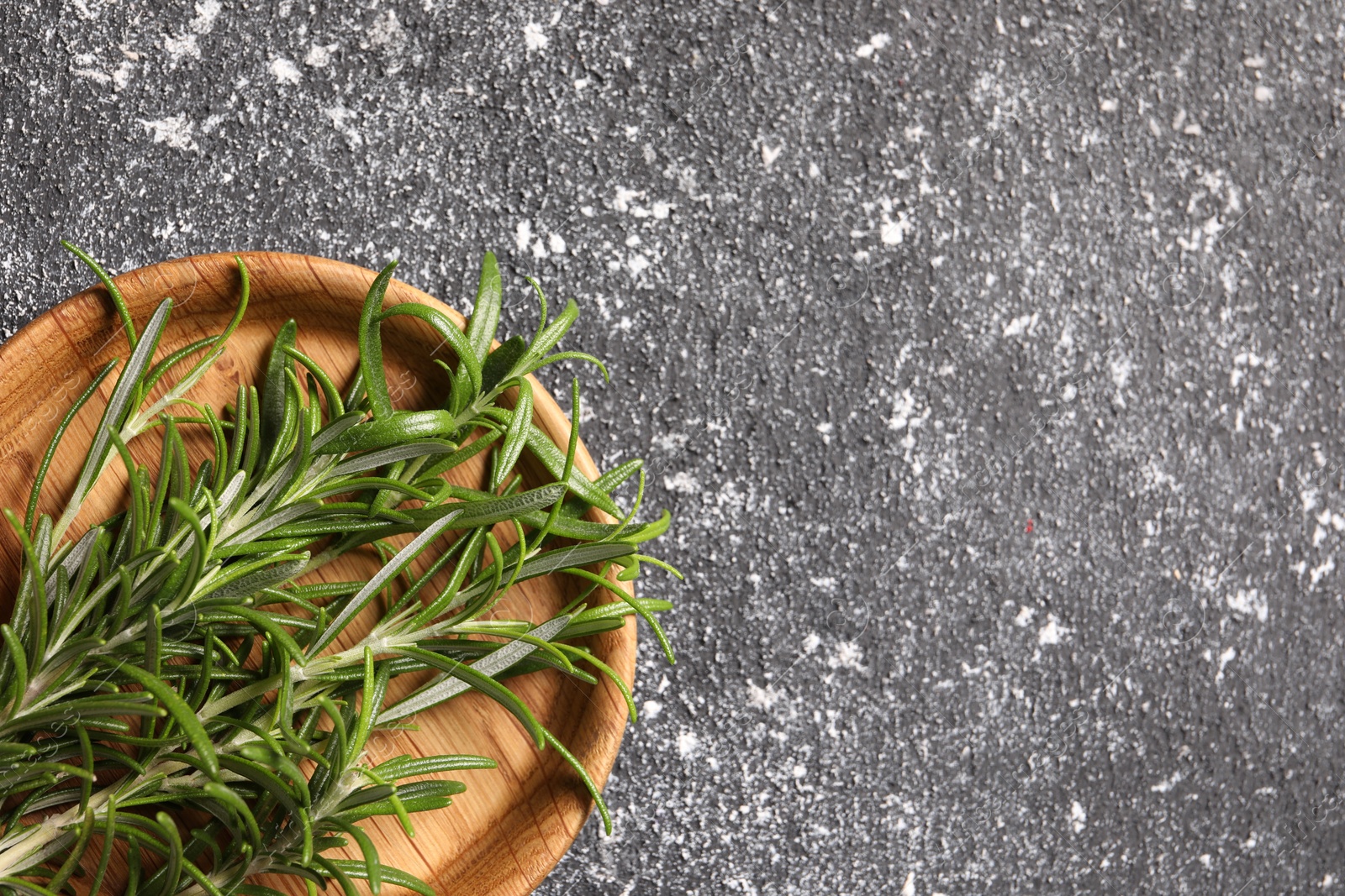 Photo of Fresh rosemary on grey textured table, top view. Space for text