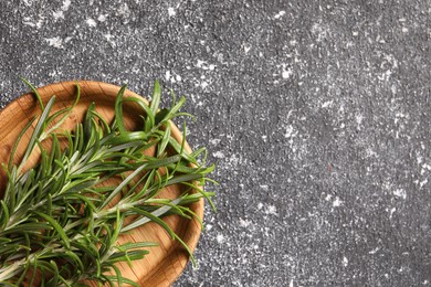 Photo of Fresh rosemary on grey textured table, top view. Space for text