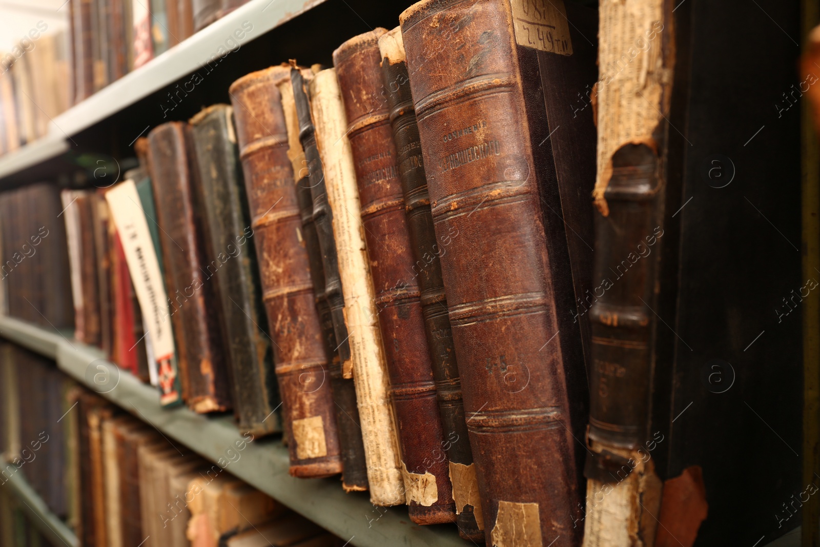 Photo of Old books on shelf in library, closeup
