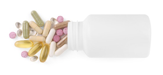 Photo of Bottle and different vitamin pills isolated on white, top view