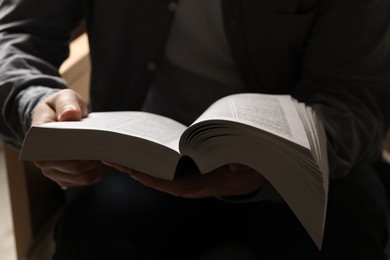 Photo of Man sitting and reading holy Bible, closeup