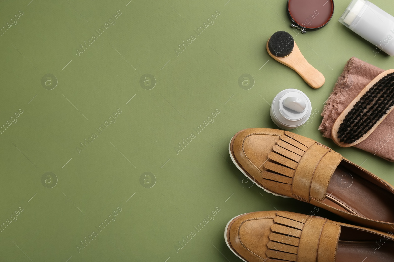 Photo of Flat lay composition with shoe care accessories and footwear on green background. Space for text