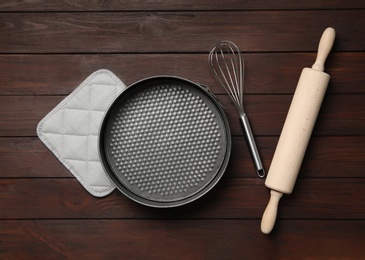 Set of modern cooking utensils on brown wooden table, flat lay