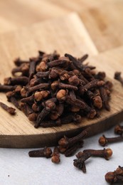 Pile of aromatic cloves on light table, closeup