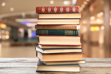 Collection of different books on wooden table against blurred background