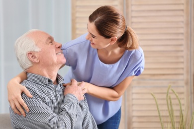 Elderly man with female caregiver at home
