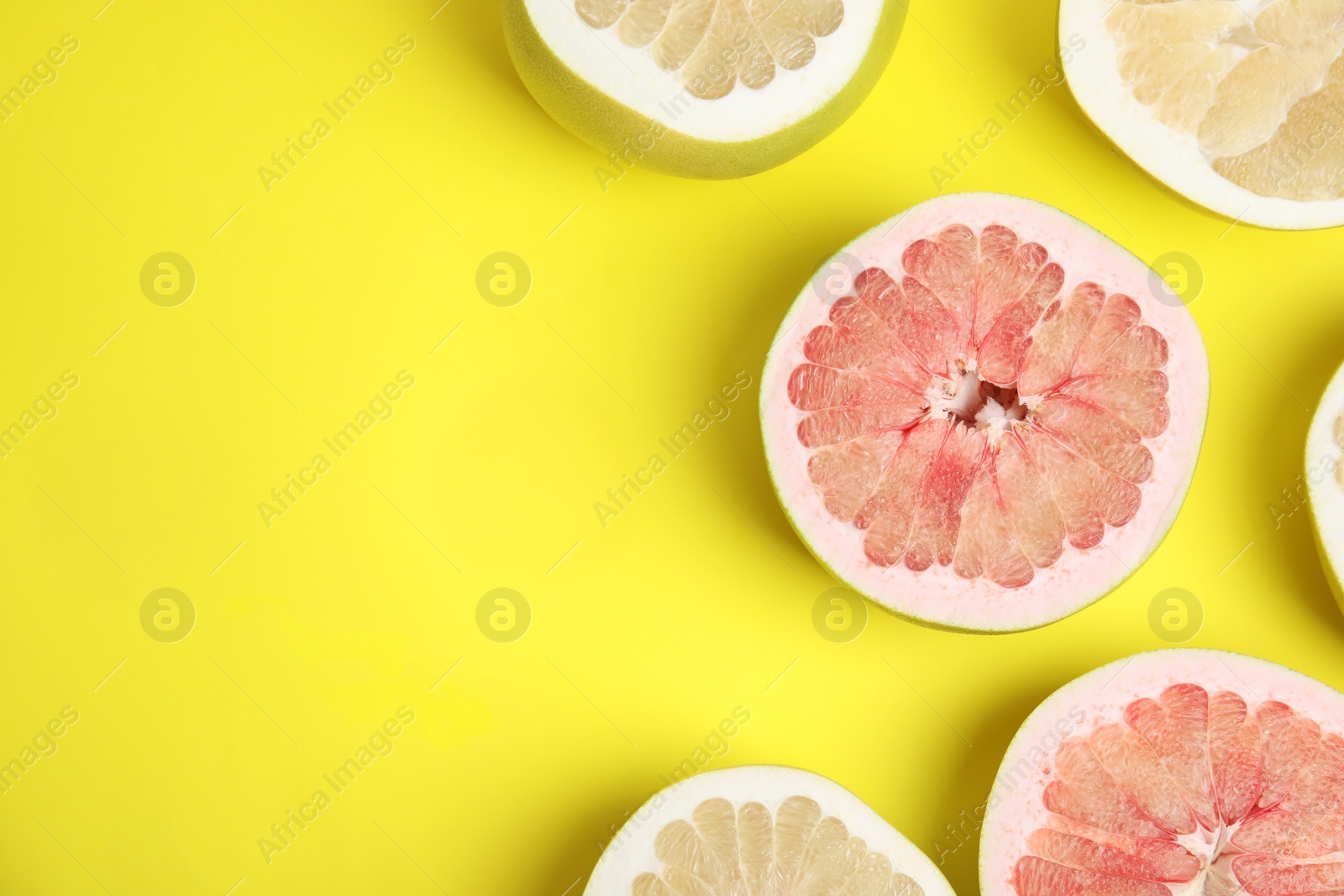 Photo of Fresh cut pomelo fruits on yellow background, flat lay. Space for text