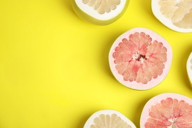 Photo of Fresh cut pomelo fruits on yellow background, flat lay. Space for text