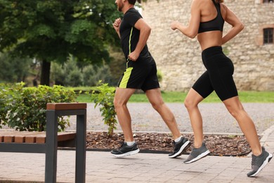 Photo of Healthy lifestyle. Couple running in park, closeup with space for text