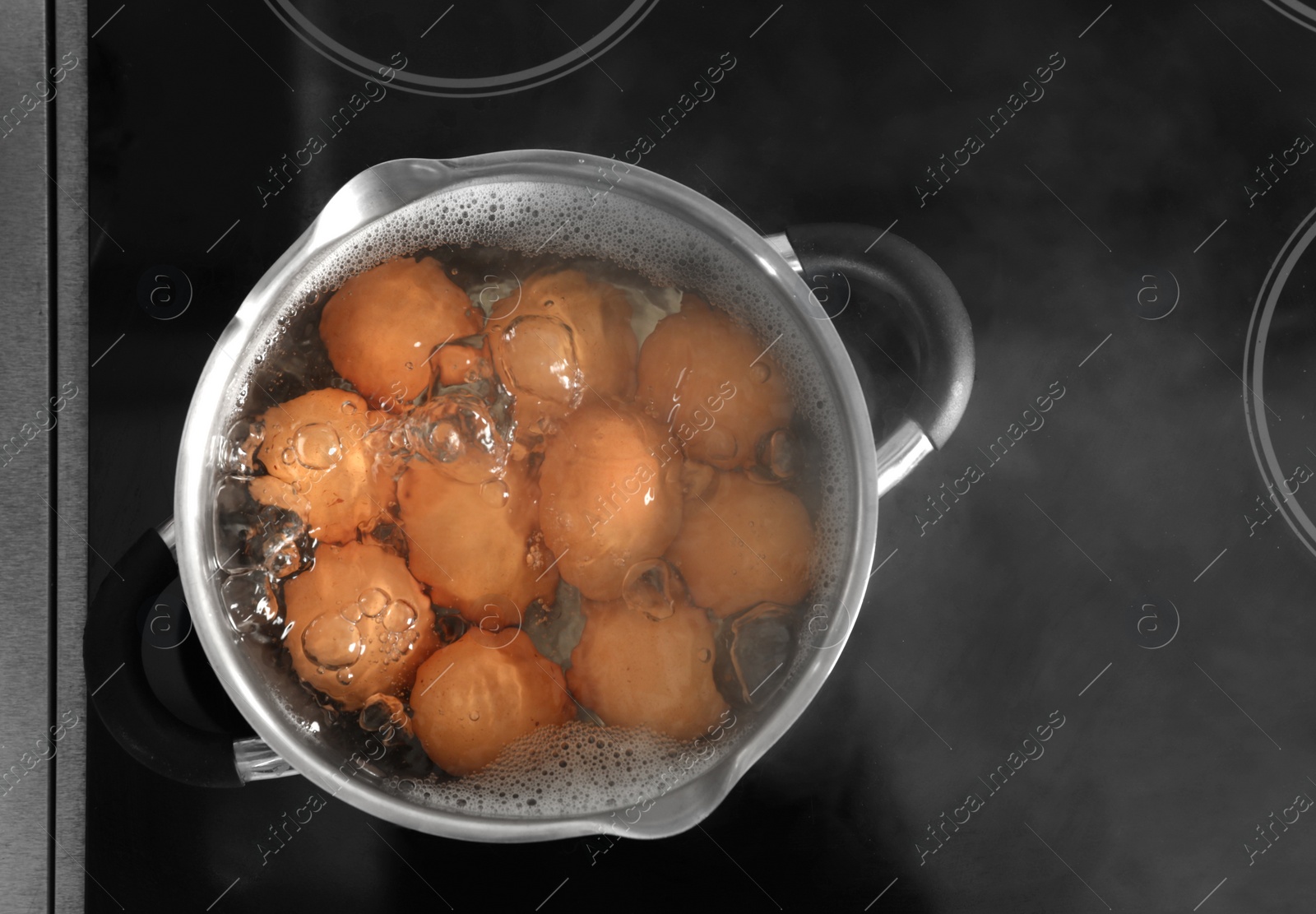 Photo of Cooking chicken eggs in pot on electric stove, top view. Space for text