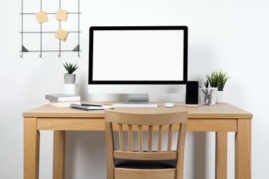 Photo of Cozy workspace with computer and stationery on wooden desk at home