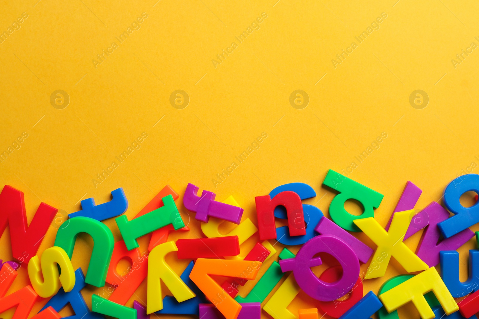 Photo of Plastic magnetic letters on color background, top view with space for text