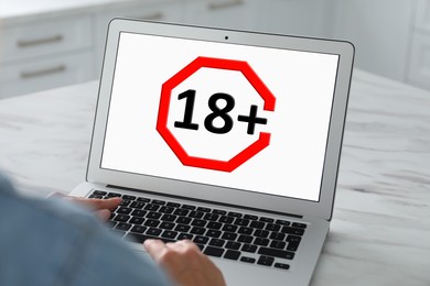 Image of Woman using laptop with age limit sign 18+ years indoors, closeup